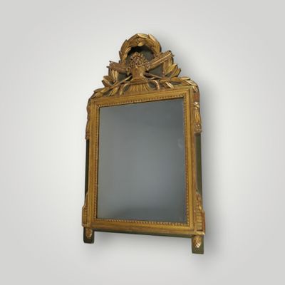 an image of a gold framed mirror on a white wall