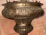 a bronze bird on a pedestal on a brick floor