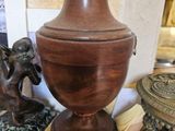 une urne en bois posée sur une table à côté d'une statue