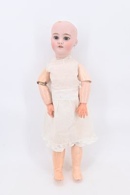 une image représentant une poupée chauve vêtue d'une robe blanche