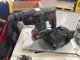 a corded drill sitting on top of a laptop computer