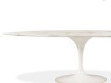 an oval marble dining table with a white base