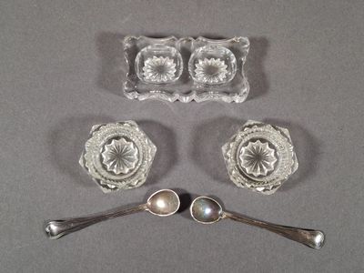 three pieces of glass with spoons and spoon rest on a table