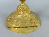 a gold vase with a bird on top of it