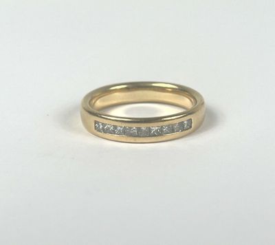 a close up of a gold ring with diamonds on a white background