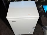 a small white box sitting on the floor next to a tv