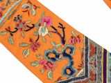 an orange neck tie with a floral design on a white background