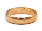 gros plan d'une bague en or sur fond blanc