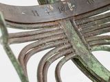 a close up of a metal bench with a green patt finish