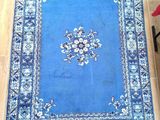 rug on the floor of a living room with a chair and a table