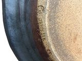 a close up of a pot on a white surface