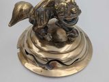 bronze figurine of a dog on a pedestal with a ball