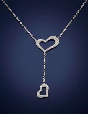 un collier en or blanc orné d'un cœur et d'une clé suspendus à une chaîne
