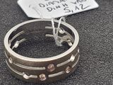 une bague en argent ornée de pierres roses sur un fond noir