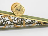 une horloge posée sur une étagère sur laquelle se trouve une autre horloge