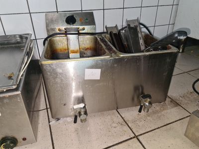 deux éviers en acier inoxydable dans une cuisine où s'accumulent les assiettes sales