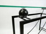 une table en verre sur laquelle se trouve une boule noire