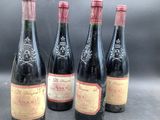 four bottles of wine are lined up on a table