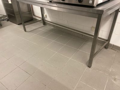 une table argentée sur laquelle se trouve un micro-ondes, dans une cuisine
