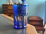 a blue glass sitting on top of a wooden table