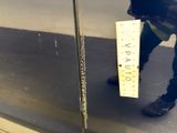 a man standing in front of a glass door holding a ruler