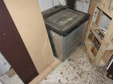 une machine à laver et un sèche-linge sales, dans un coin de la pièce