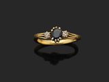 une bague en or sertie d'un diamant noir et de deux diamants blancs