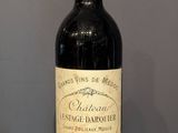 une bouteille de vin posée sur un tonneau en bois