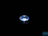 a close up of a blue sapphire on a black surface
