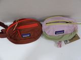 two fanny bags are lined up on a white surface