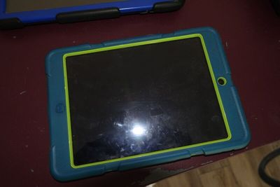 une tablette bleue et verte posée sur une table