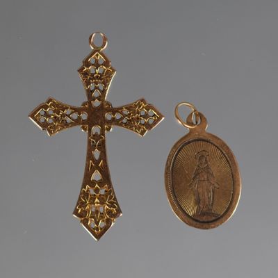 two gold crosses and a medal are shown against a gray background