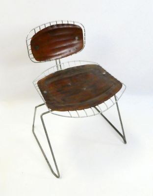 a metal chair that has a wooden seat on it