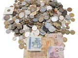 une liasse de billets posée sur une pile de pièces