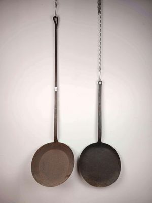 deux casseroles accrochées au mur l'une à côté de l'autre
