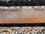 a rusted piece of metal on the ground next to rocks