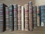many old books lined up on a wooden table