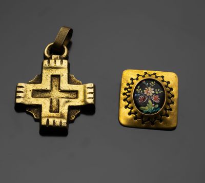deux croix en or et un petit pendentif orné d'un motif floral