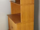 a tall wooden bookcase next to a dresser in a room