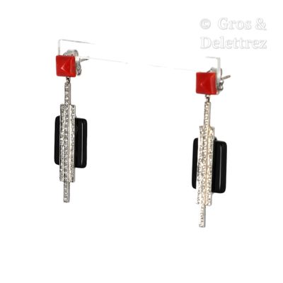 une paire de boucles d'oreilles noires et blanches ornées de pierres rouges et de diamants