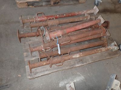 a pile of rusty pipes on a pallet in a warehouse