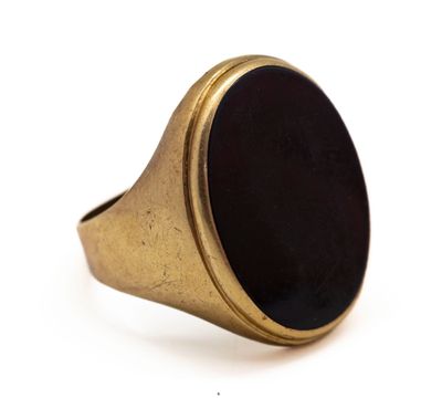 gros plan d'une bague en or avec une pierre noire