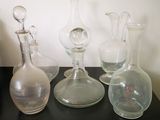 de nombreux vases en verre posés sur une table noire
