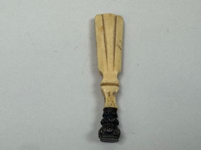 une pagaie en bois avec un manche noir sur un fond blanc