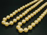 un gros plan sur un collier de perles posé sur une surface noire
