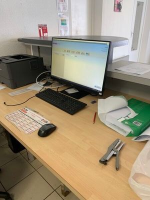 un bureau sur lequel se trouvent un ordinateur, un clavier, une souris et d'autres objets