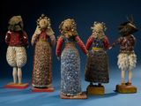 several figurines of people are lined up in a row on a blue surface
