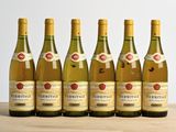 six bouteilles de vin sont alignées sur une table en bois
