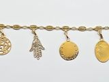 a close up of a gold bracelet with five charms on it