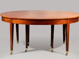 une table de salle à manger ovale avec quatre pieds et un plateau en bois